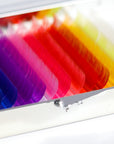 Close-up of creative colored lash extensions showing rainbow palette including pink, blue, green, purple, and yellow shades